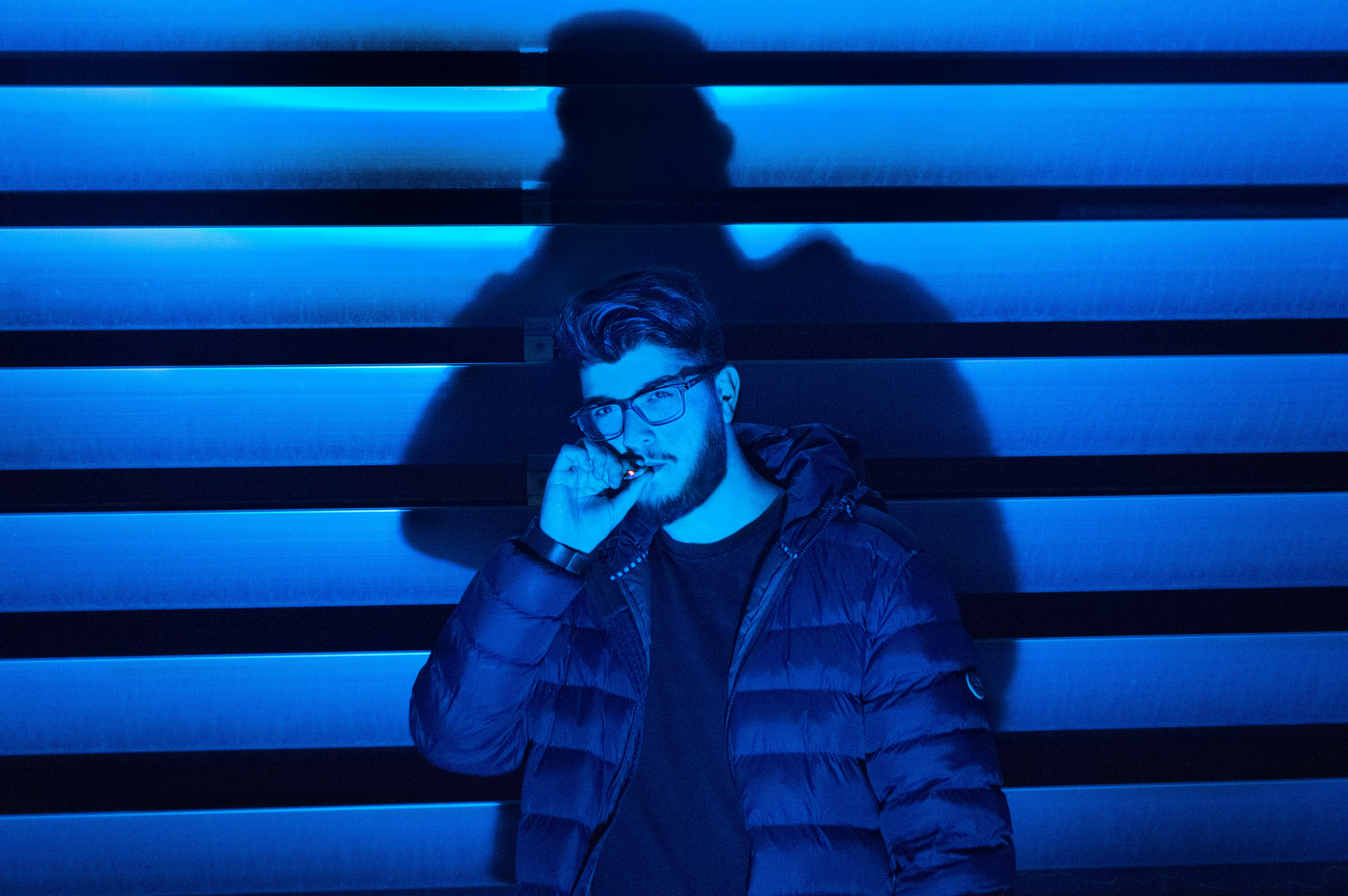 man smoking standing near wall